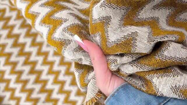 A heavy duty upholstery fabric features a bold gold and white chevron zig zag pattern with a textured jacquard weave for durable furniture covers pillows and modern interior home decor projects