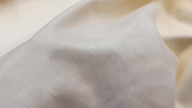 The premium cream white gabardine twill fabric displays a fine diagonal weave and a soft smooth finish. This durable material is perfect for creating high quality tailored suits and trousers.