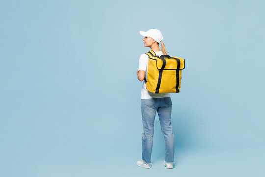 Full body delivery employee woman wear white cap T-shirt uniform yellow thermal food bag backpack workwear work as dealer courier isolated on plain pastel light blue background studio Service concept