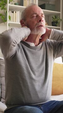 Unwell senior man massaging his aching neck