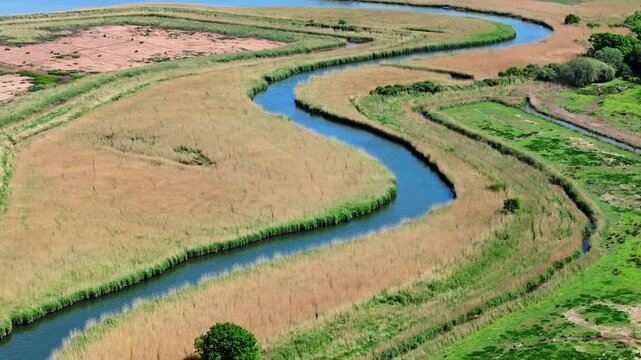 Aerial shot of meandering River Trent or Piddle through Salt Marsh and Reed beds near Poole, UK
