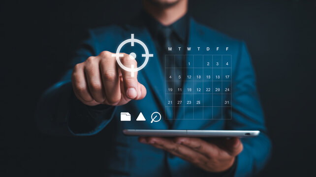 Business person using tablet device with digital planning calendar and target icon for project management or goal setting.