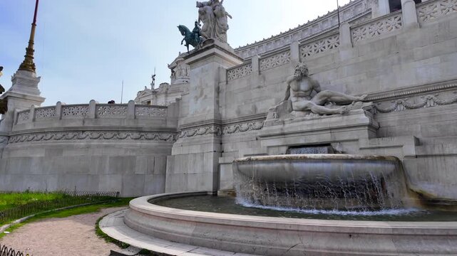 Wide angle view of the monumental stone fountain and classical statues at the Altare della Patria in Rome