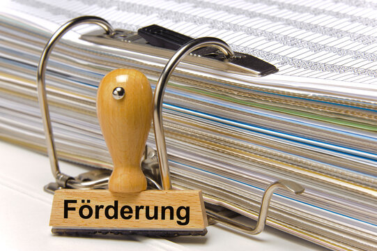 Ein Holzstempel ist beschriftet mit dem Aufdruck F&ouml;rderung