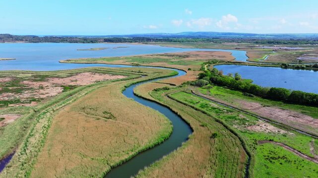 Aerial shot of meandering River Trent or Piddle through Salt Marsh and Reed beds near Poole, UK