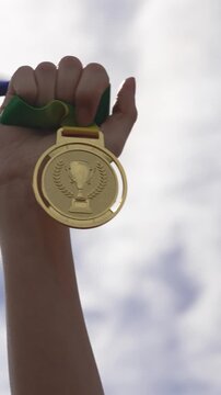 Champion Lifts Medal High Triumphantly. Medal Of Gold Lifted Skyward With Joyful Victorious Stance