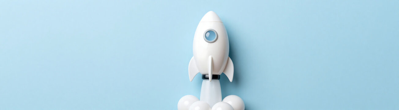 white plastic easter egg shaped like rocket blasts soft blue pastel hued background eye level shot directly