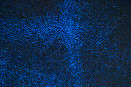 Close up of blue leather surface with visible texture detail for backgrounds