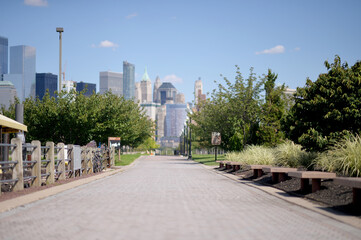 Fototapeta premium Quiet Early Morning Along Hudson River With City Reflections And Benches new york