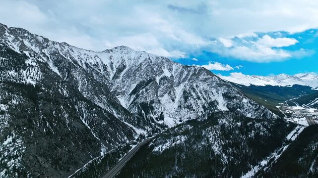 Frisco Gulch expansive mountain valley with snowy ridges and evergreen forest, aerial drone overview