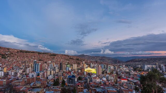 Timelapse sequence of La Paz transitioning from day to night with dense urban buildings and mountain landscape. Bolivia skyline at sunset.