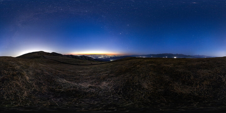 Panoramic Night Sky Over Hills and Distant City Lights, equirectangular projection