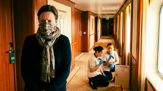 Woman wearing a mask looking worried while staff cleans on cruise liner - Concept of Hantavirus Pulmonary Syndrome (HPS) cruise liner, pandemic, virus  