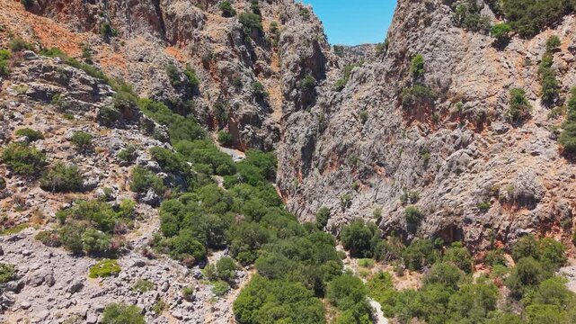 Aerial drone shot flying through Kritsa Gorge in Crete during a hot summer day