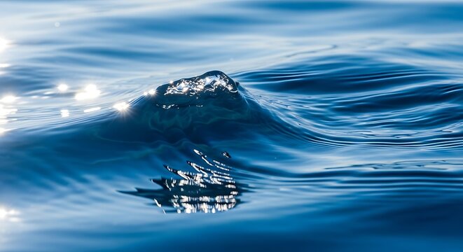 Sparkling water wave crest closeup with ocean abstract background, and blue reflection.