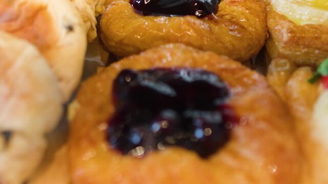 Assorted Fresh Fruit Danishes and Sweet Buns in a Bakery Display Case