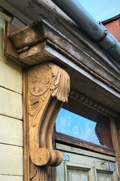 Close-up of intricately carved wooden corbel on aged facade, showcasing traditional craftsmanship, texture and historic architectural elegance in natural light