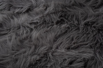 Soft fluffy fabric texture abstract background in dark gray color with long shaggy faux fur © reddish