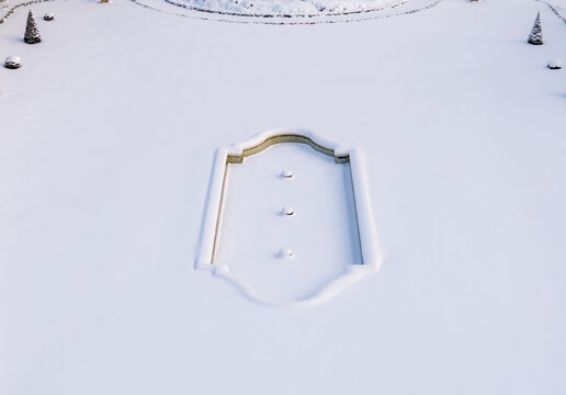 Aerial view of the snow-covered fountain and minimalist garden at Traku Voke Manor in winter Vilnius, Vilniaus apskritis, Lithuania.
