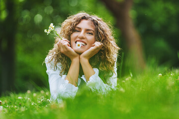 Obraz premium Pretty smiling authentic girl with camels flowers relaxing outdoor in summer by sunlight.