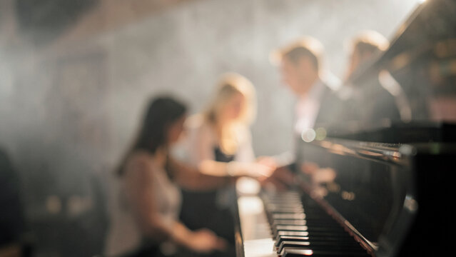 Professional musicians playing grand piano performance in concert hall