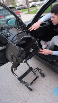 Independent businessman with a physical disability skillfully assembling his wheelchair after parking his car in a designated parking space