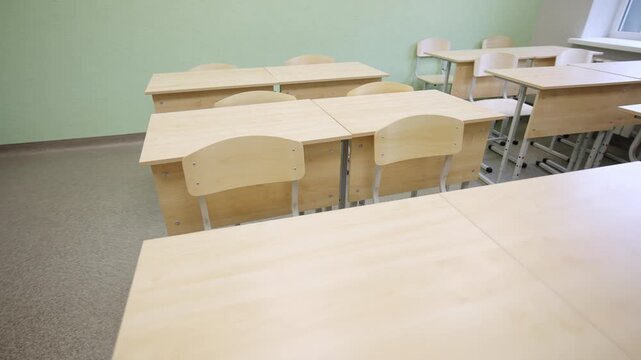 Educational facility interior shows orderly arranged classroom desks. View evokes sense of structure and readiness for productive lessons