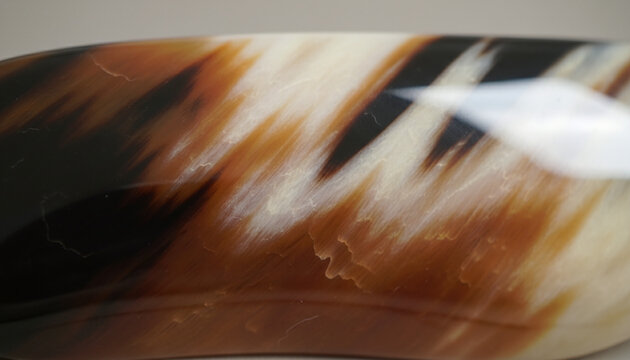 Polished genuine buffalo horn texture with caramel brown and black streaks