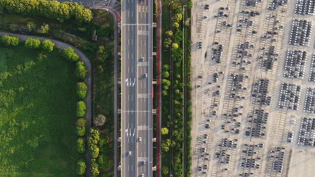 Top down aerial view of car export yard and port access road with vehicles in rows