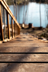 Fototapeta premium Rustic wooden steps in a Nordic forest landscape leading to the riverbank,