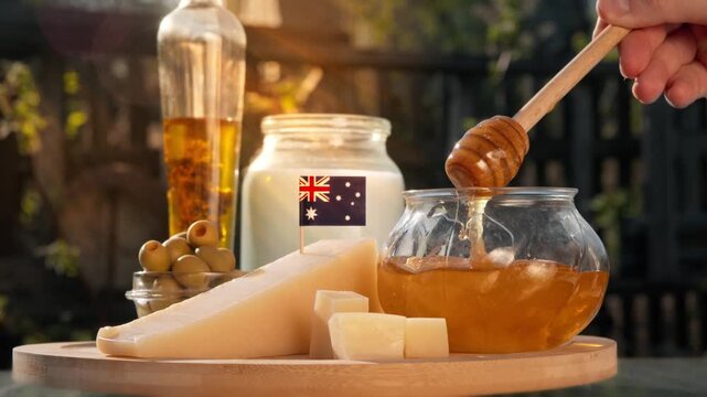 Farm fresh Australian produce including cheese, manuka honey, and dairy goods is presented in soft natural light with a warm homely feeling beneath the country flag.