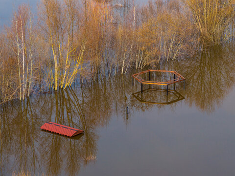 Aerial view of a flooded park area with submerged trees, a red roof, and a hexagonal wooden structure reflecting in the water Kedainiai, Kaunas County, Lithuania.