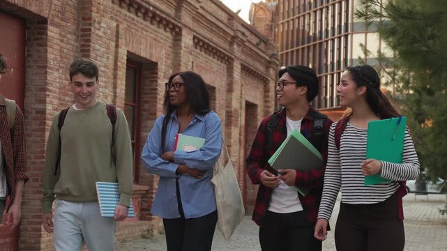 Diverse group of university students walking and talking on campus