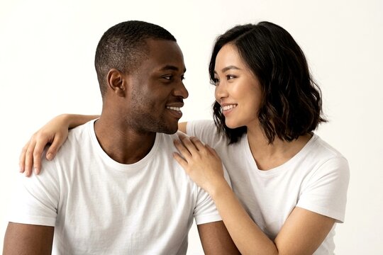 Happy Multicultural Couple Smiling and Looking at Each Other Isolated on White Background