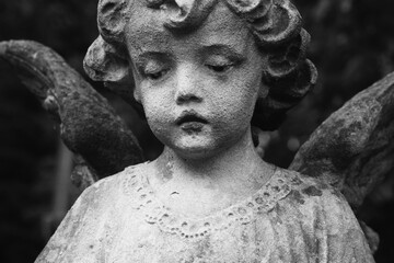 Naklejka premium Vintage cherub sculpture symbolizing innocence and remembrance