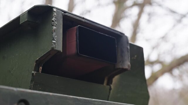 Armored vehicle exhaust outlet releasing fumes in outdoor environment with muted colors