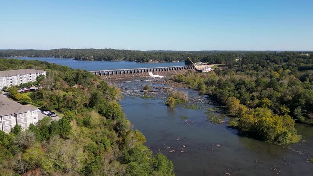 Oliver Dam on Chattahoochee River between Columbus Georgia and Phenix City Alabama built in 1959 by Georgia Power forms Lake Oliver reservoir with hydroelectric turbines as drone pullback