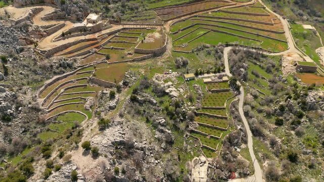 Aerial view of layered agricultural terraces and winding rural roads in Douma, Lebanon, highlighting the traditional mountain farming landscape.