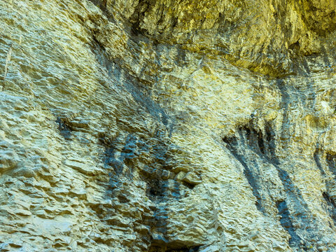 Rock formations in a natural landscape show layers and textures, capturing the essence of geological history and the setting of a remote outdoor area during daylight hours