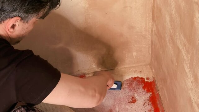 Worker treating wall corner against mold before priming, home renovation process, repair and cleaning concept.
