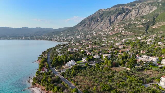 Aerial Drone View of Mikri Mantineia Coastal Village Near Kalamata With Mountain Slopes, Olive Groves, Road and Blue Mediterranean Sea in Greece