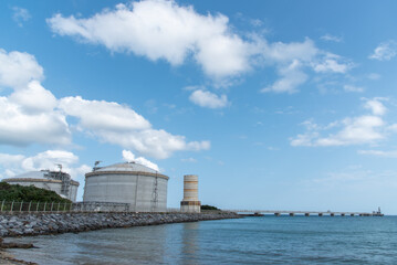 Obraz premium 沖縄の天然ガス火力発電所のLNGタンクと海上に伸びるパイプ