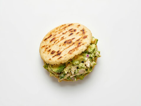 Arepa venezuelana ripiena con pollo e avocado su sfondo chiaro. Generative AI 