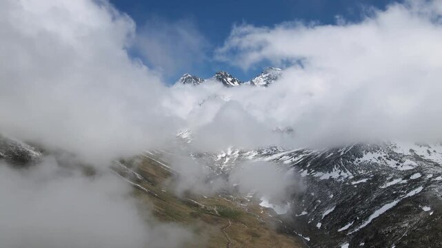 Snowy, cloudy mountains formed by steep cliffs. Peaks that are hard to reach.