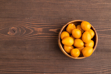 Pile of smoked quail eggs in bowl on a brown wooden background. top view, copy space. © zgurski1980