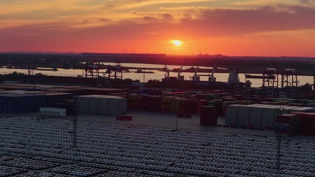 Dramatic sunset over harbor cranes and container terminal silhouettes