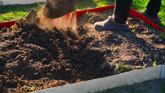 Man digging vegetable garden bed soil with shovel close-up slow motion