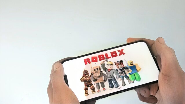 Jakarta, ID - May 11, 2026: Close Up Hand Hold Smartphone Playing Roblox Game
