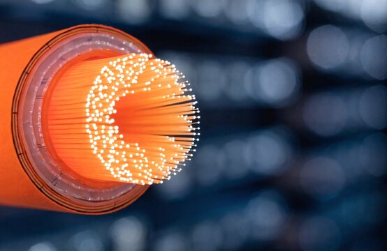 Bright orange fiber optic cable glowing with transmitted light, cable jacket cross-section, data center panel