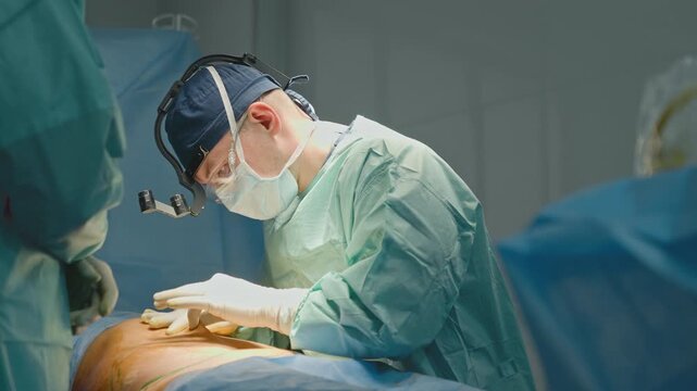 Skilled doctor surgeon in protective uniform man physician in operating room with team of nurse assistants prepare for operation in sterile environment modern clinic surgery medicine transplantation